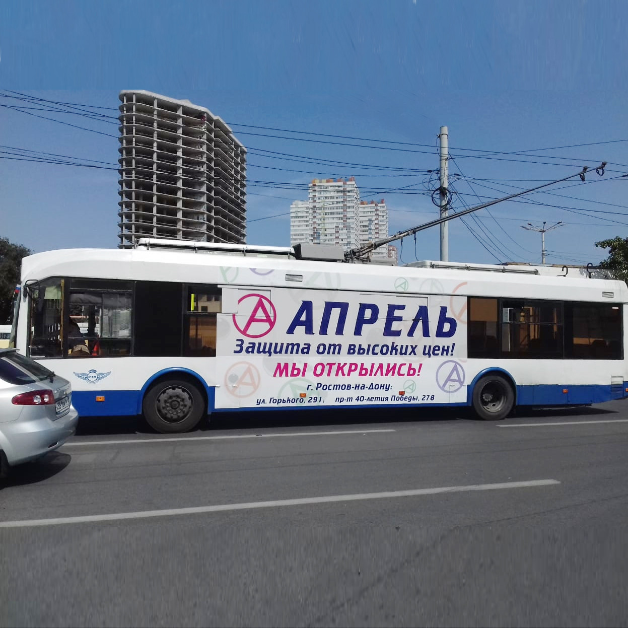 Троллейбус белый с рекламой Апрель